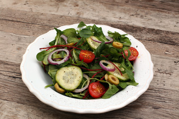 Caprese. Caprese salad. Italian salad. Mediterranean salad. Italian cuisine. Mediterranean cuisine. Tomato mozzarella basil leaves black olives and olive oil on wooden table. Recipe - Ingredients