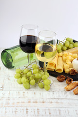 Bottle of white wine, grape and corks on wooden table