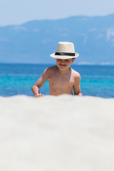Young boy  playing with water pistol by the sea