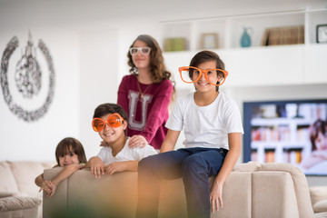 Funny kids with silly glasses on eyes at home