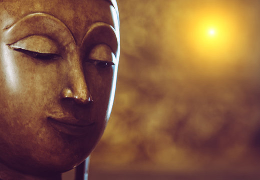 Selective focus Face of bronze buddha statue with Bokeh background and lighting effect.