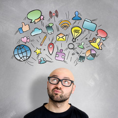 Multimedia icons going out of the head of a young attractive man