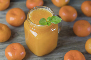 Freshly squeezed healthy citrus tangerine juice in jar and ripe