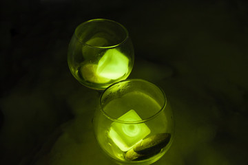 glasses with the glowing cocktail on the background of snow