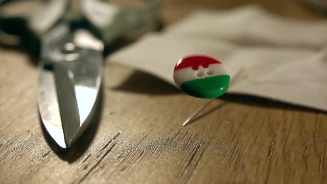 Super slow motion shot of falling and bouncing Italian flag button. Made in Italy concept
