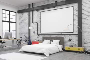 Side view of bedroom interior with white walls and a poster on them. There is a large bed, an...