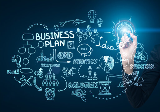 Close up of a businessman's hand drawing a business idea sketch with a glowing blue pen on a glassboard.