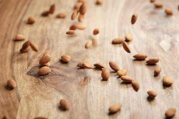 peeled almonds spread on old wooden table, healthy food