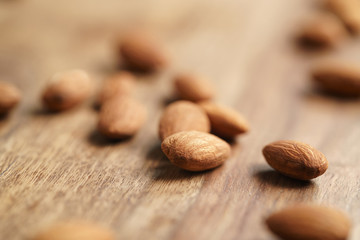 peeled almonds spread on old wooden table, healthy food