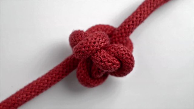 Knot in a red string spinning on itself.