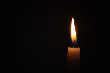 tall candle blown in the dark environment, shallow focus