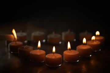 Fototapeta na wymiar setting tealight candles in a shape of a heart, shallow focus photo