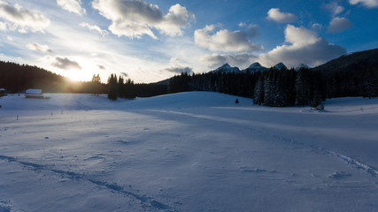 Sun rising above snow covered meadow.