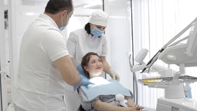 Doctor and nurse preparing a patient for dental exam.