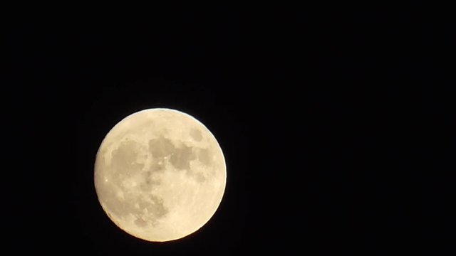 Full  Moon rising up. Night moon motion in the sky. Mystical view on star. Astronomical survey of planets in real time. Astrotheme planet with craters and seas uninhabited land in Universe.