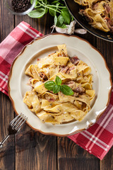 Pappardelle pasta with prosciutto and cheese sauce on a plate