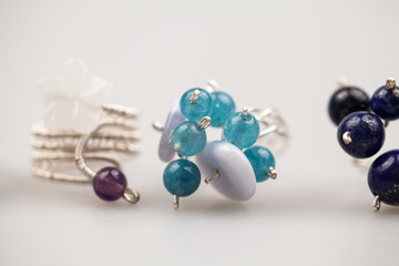 Silver rimgs with colorful precious stones and light grey background