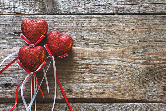 Valentines day. Red hearts on wooden background closeup with copy space for congratulation. Vintage toning