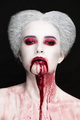Mysterious beauty portrait of snow queen covered with blood. Bright luxury makeup. Gore dripping...