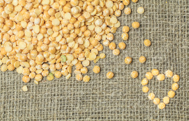 Top view of Dry yellow split peas chickpeas forming heart symbol