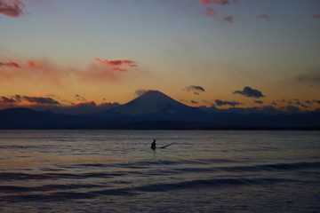 片瀬西浜海水浴場から望む湘南海岸と富士山夕景とサーファー