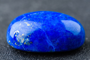 Rich blue lapis lazuli oval cabochon with small golden spots.