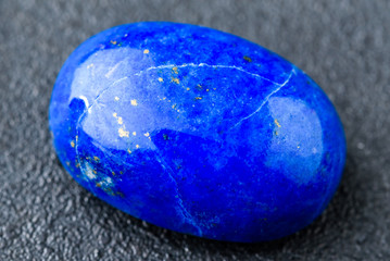 Rich blue lapis lazuli oval cabochon with small golden spots.