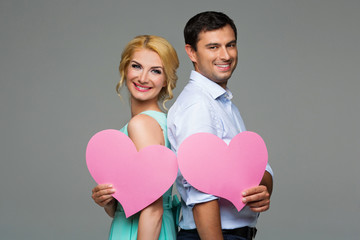 Beautiful couple holding pink hearts