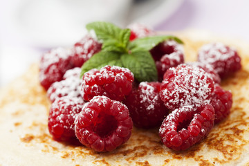 Stack of Russian-style pancakes with raspberries
