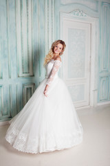 Portrait of charming woman in wedding dress. Dancing on the background walls with classic moldings