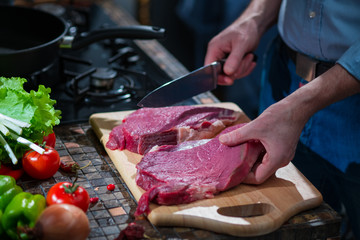 The man cut a piece of meat in half