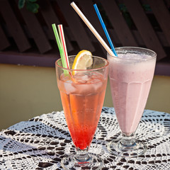 Smoothies in glasses, drink at juice bar or cafe. Bluberry milkshake and Strawberry lemonade.