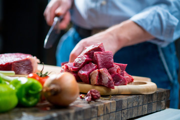 The man cut the meat into small pieces