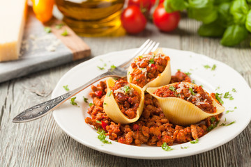 Italian pasta Conchiglioni Rigati stuffed with dry tomatoes and