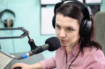 A radio DJ announces news in a radio-studio