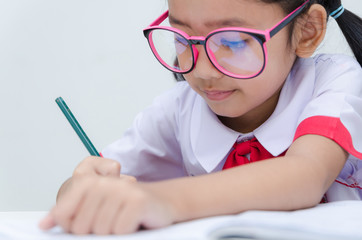 Naklejka na ściany i meble Close up shot of Asian little girl doing homework in Thai Studen