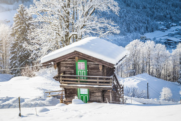 Traditional wooden mountain chalet in scenic winter wonderland scenery in the Alps