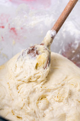 Mixing and preparing pizza or bread dough with wooden utensil