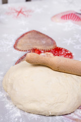 Pizza dough on the table with rolling pin