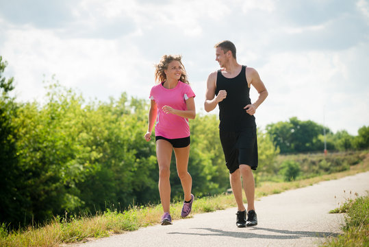 Portrait of cheerful couple running outdoors