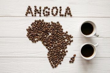 Map of the Africa made of roasted coffee beans and two cups of coffee on white wooden textured background with space for text