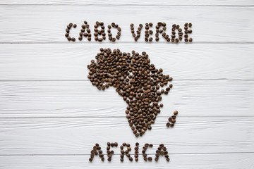 Map of the Africa made of roasted coffee beans and cup of coffee on white wooden textured background with space for text