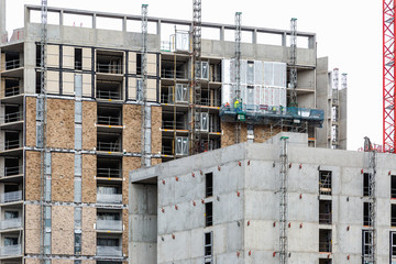 Labours work on lift platform on new development in London Dockl