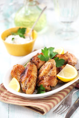Roast chicken wings platter on a white plate with parsley and lemon
