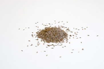 Pile of caraway seeds on a white background