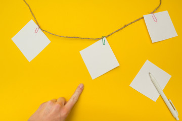 Hand pointing to the note papers hanging on a rope, empty space for text