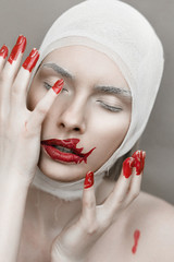 Girl with bloody fingers and shark lips. Halloween horror concept. Noisy image. Grain Texture is...