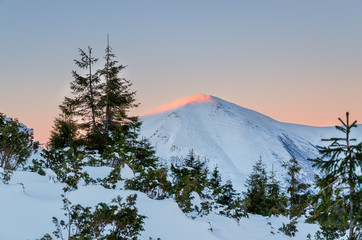 Fototapeta na wymiar Snow lanscape at the top of a mountain. Sunrise