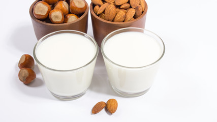 Glass of hazelnut milk and almond isolated on white background.