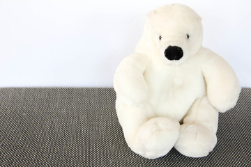polar bear doll sitting on gray floor